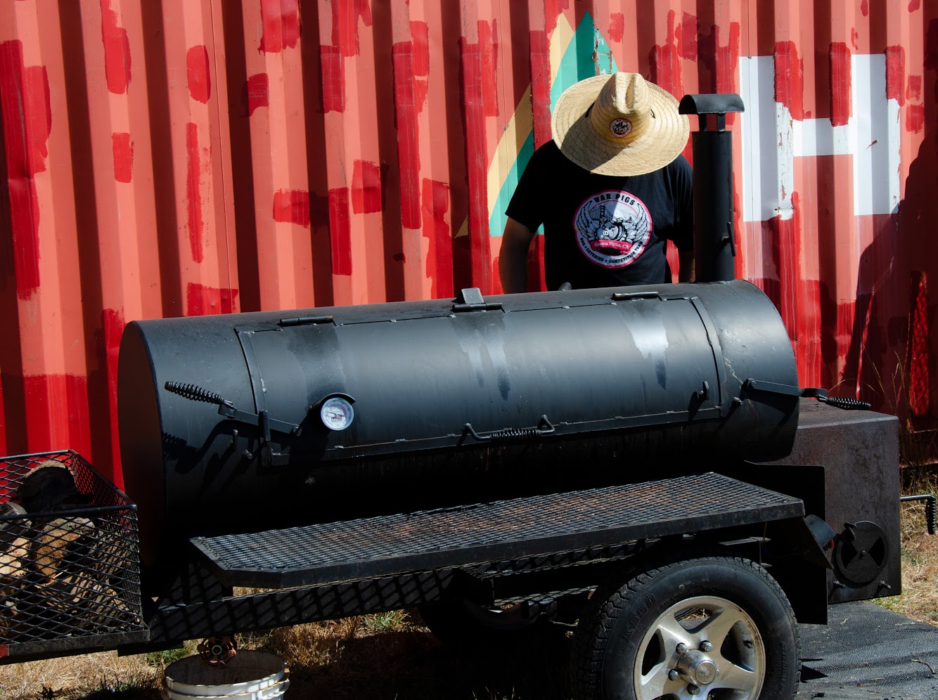 Pit master tending an offset smoker at golden hour